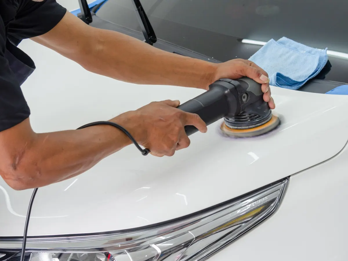 Polishing machine being used on a white car